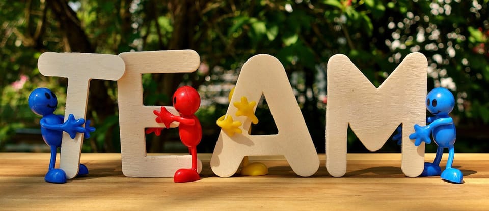 The word TEAM in large letters with small figures around it